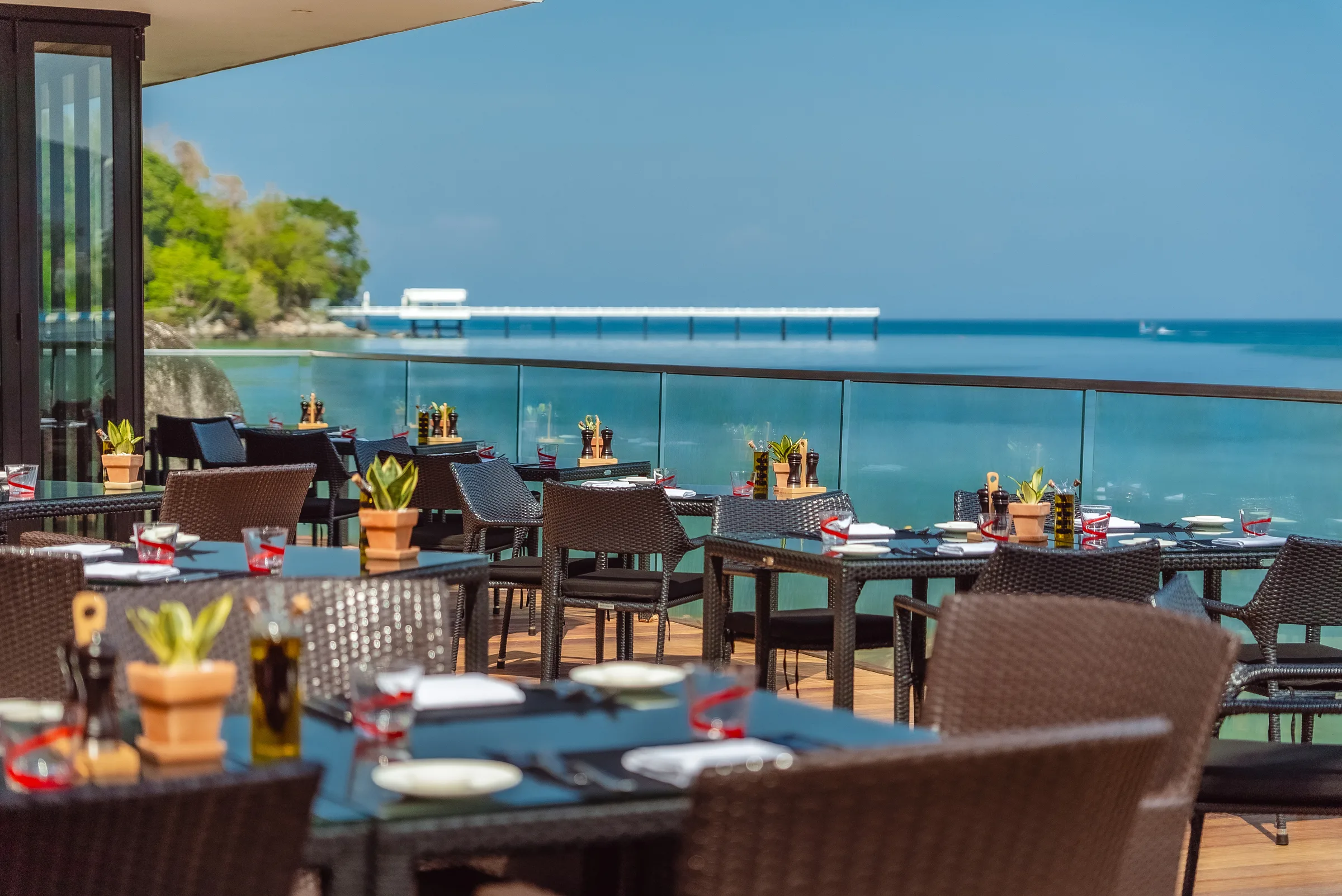 Multiple dining tables on the terrace with panoramic sea view
