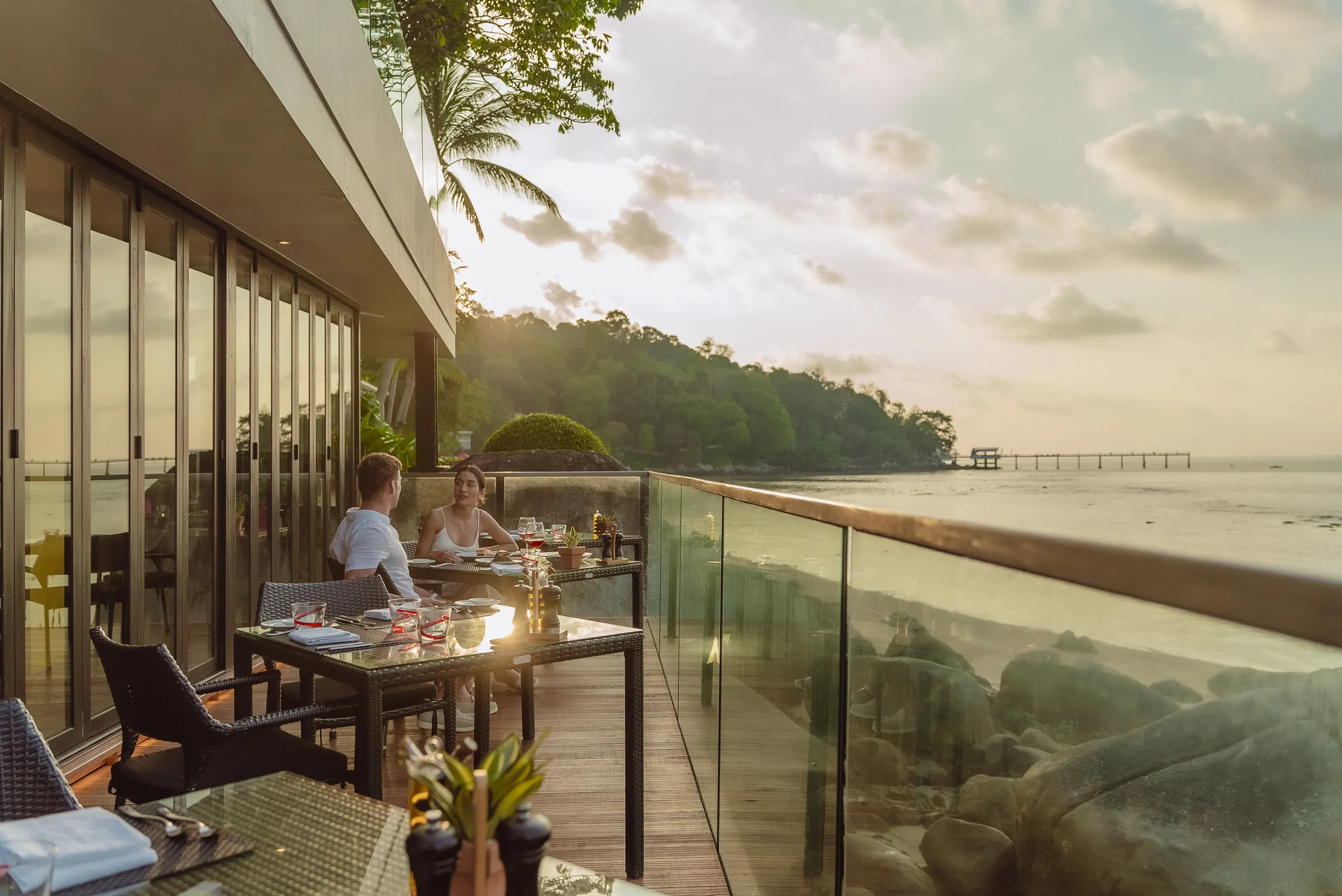 Wide panoramic view of dinner service during a spectacular sunset