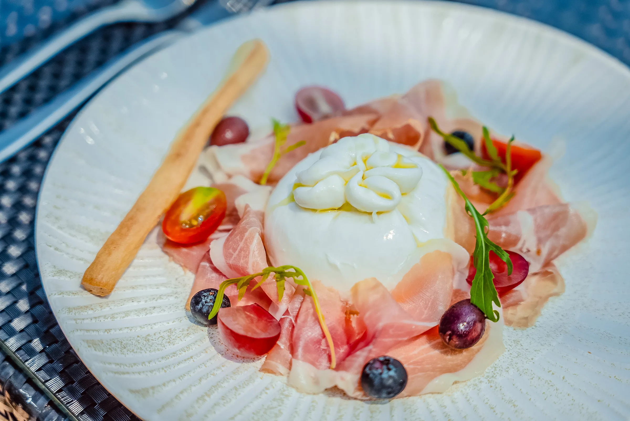 Creamy burrata cheese served with thinly sliced prosciutto crudo