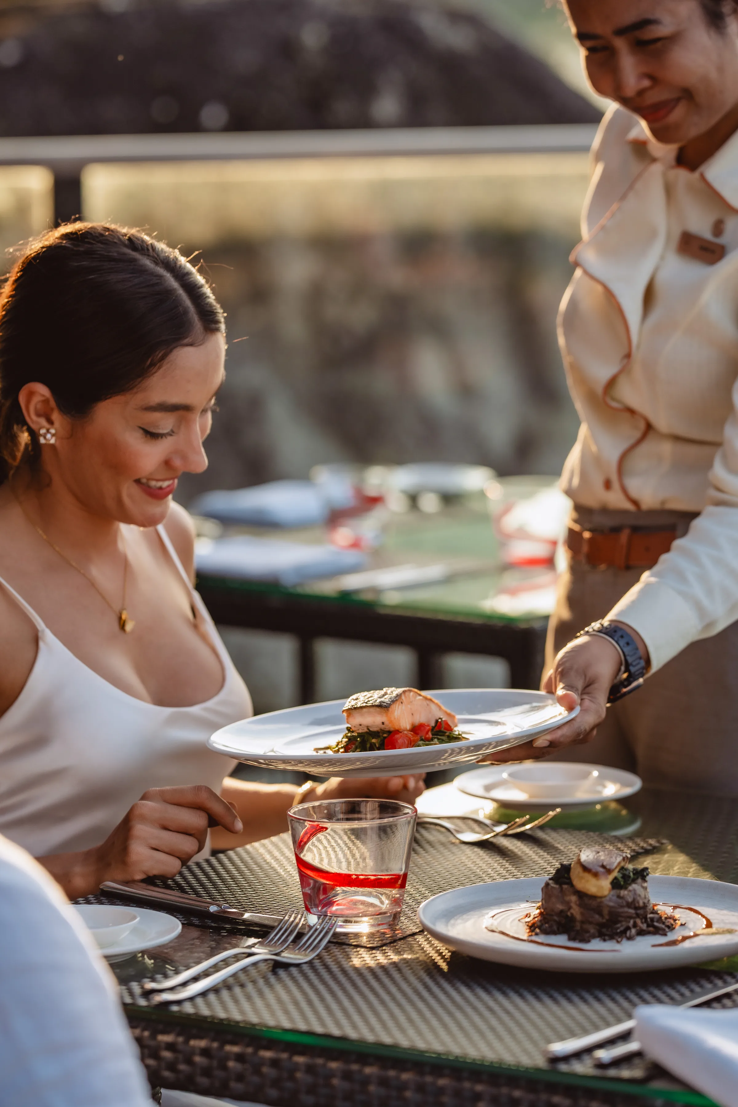 Waitress gracefully serving dishes during golden hour