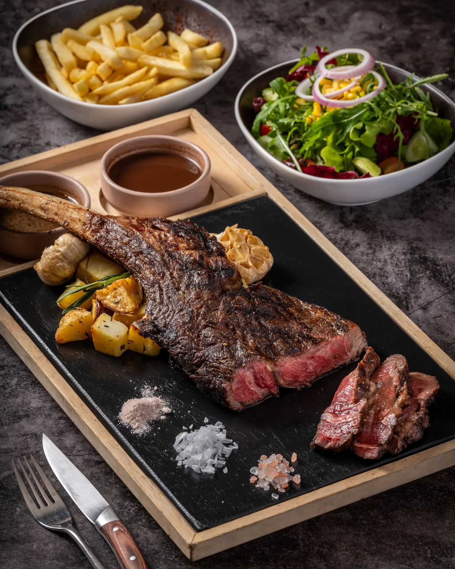 Impressive tomahawk steak seared on hot stone