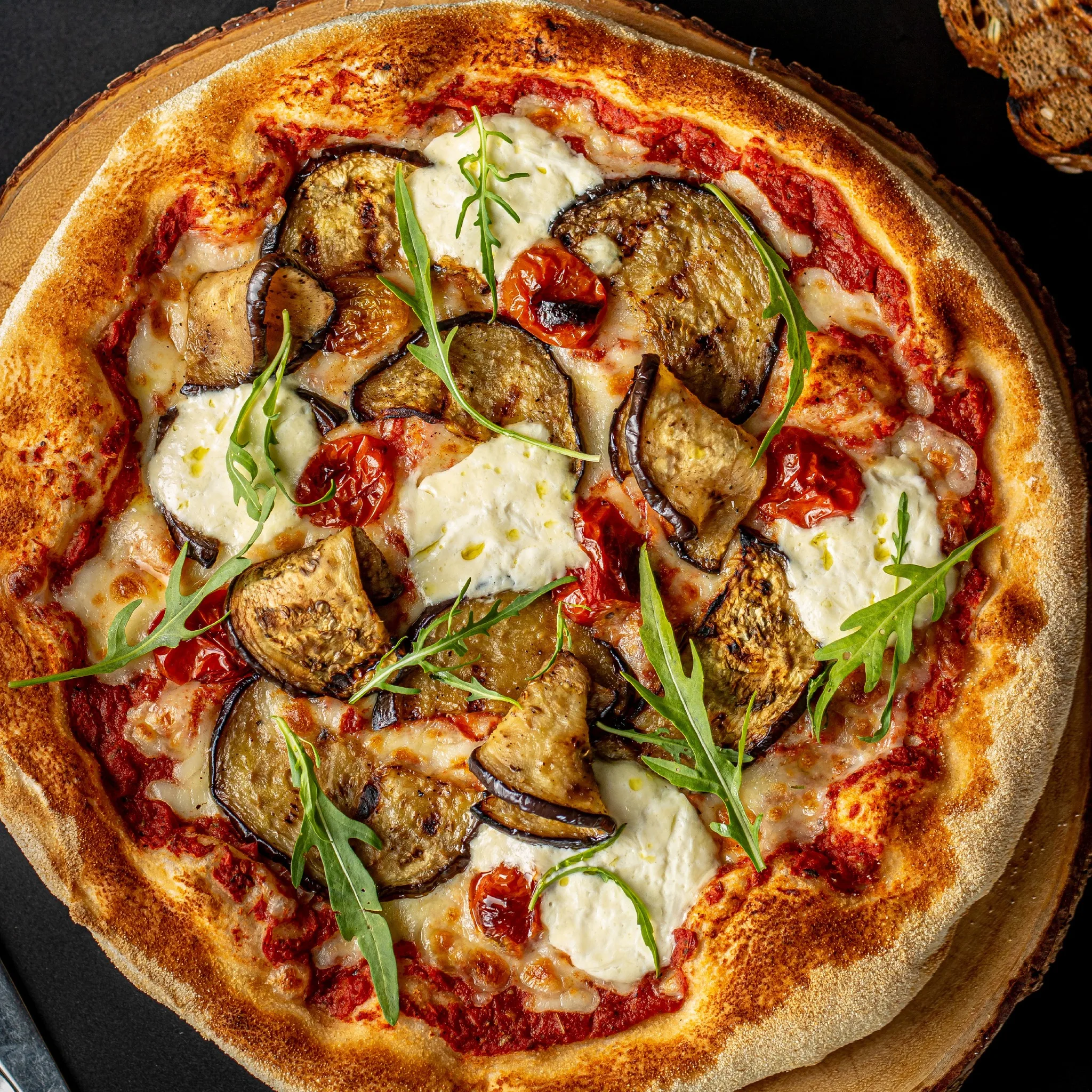 Artisan pizza topped with roasted eggplant and creamy burrata